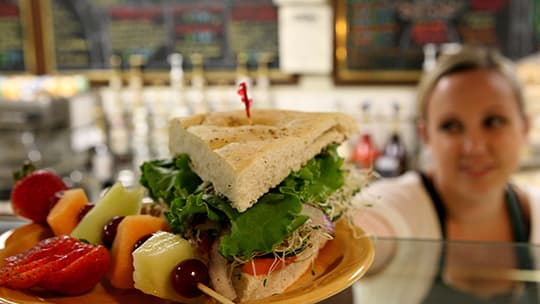 Restaurant worker placing sandwich plate on counter