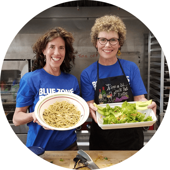 Two women showing off their plant-slant dishes